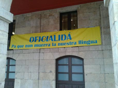Somos Avilés encolinga una pancarta na Casa Conceyu reclamando la oficialidá